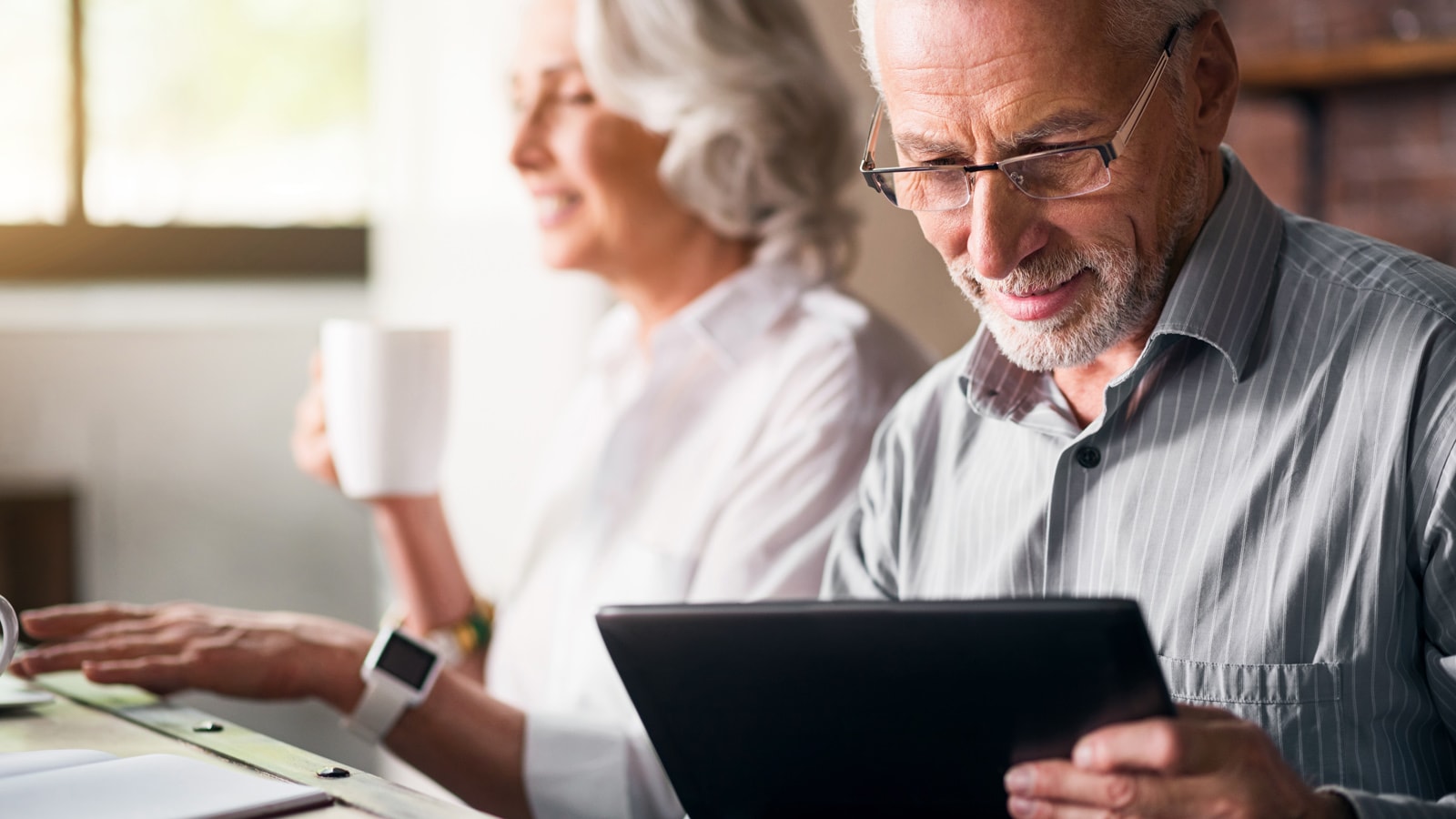 An old man holding a tablet