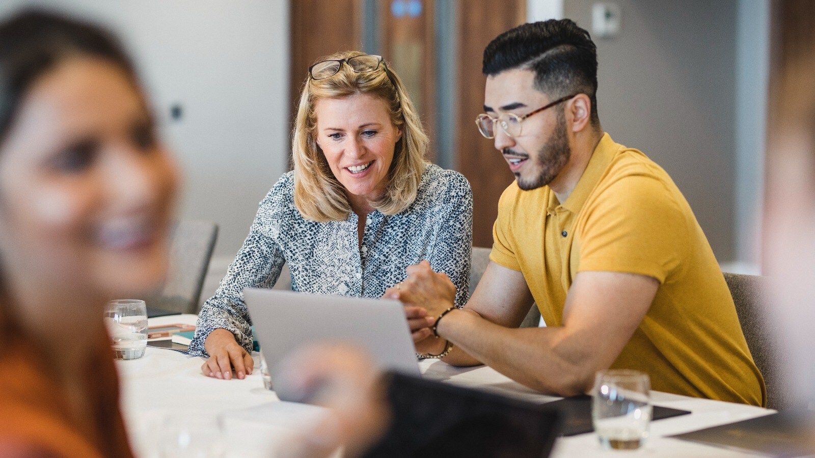two people working together on a laptop
