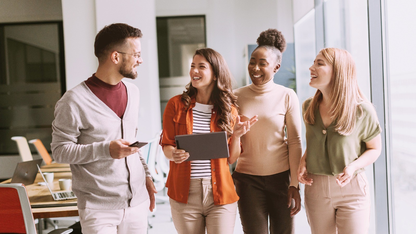 four people in an office working together and walking