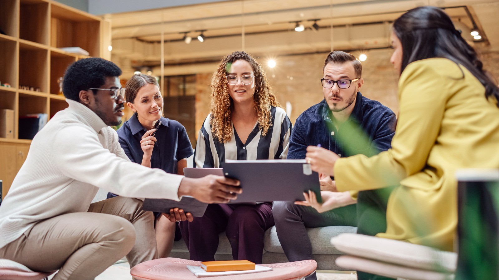 a group of students sitting together and working on a laptop